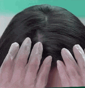 Mãos massageando a espuma no couro cabeludo